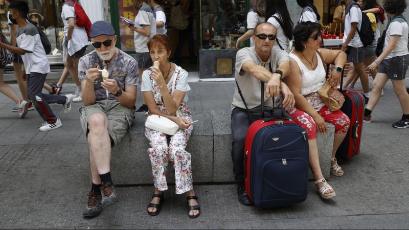 Varios turistas descansan en un banco de granito en el centro de Madrid. EFE/ Mariscal