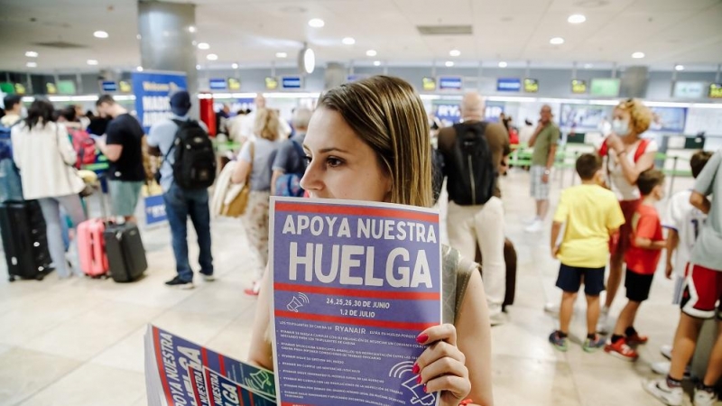 01/07/2022. Una trabajadora de Ryanair con carteles durante una concentración en la Terminal 1 del Aeropuerto Adolfo Suárez Madrid Barajas, a 1 de julio de 2022