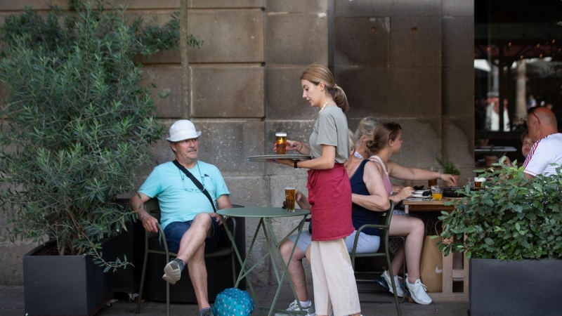 Una camarera sostiene una bandeja en la plaza Real de Barcelona, a 15 de junio de 2022, en Barcelona, Catalunya (España). Los empresarios del turismo y la hostelería han reiterado la ausencia de trabajadores en su sector