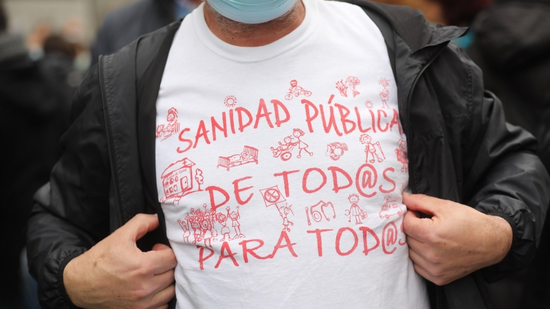 Un hombre, con una camisera que reza 'Sanidad pública de todos para todos' y 'Más sanitarios, muy necesarios', se manifiestan desde el Ministerio de Sanidad hasta la Puerta del Sol para apoyar la Atención Primaria, a 27 de marzo de 2022, en Madrid (España