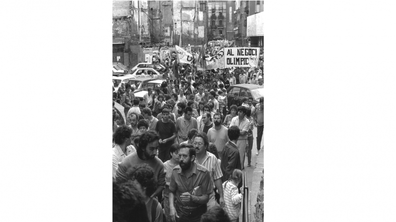 Manifestació contra el projecte olímpic passant pel Pla de la Catedral, amb el Col·legi d'Arquitectes al fons.