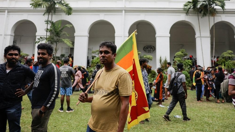 Un hombre sostiene la bandera de Sri Lanka durante la multitudinaria protesta.