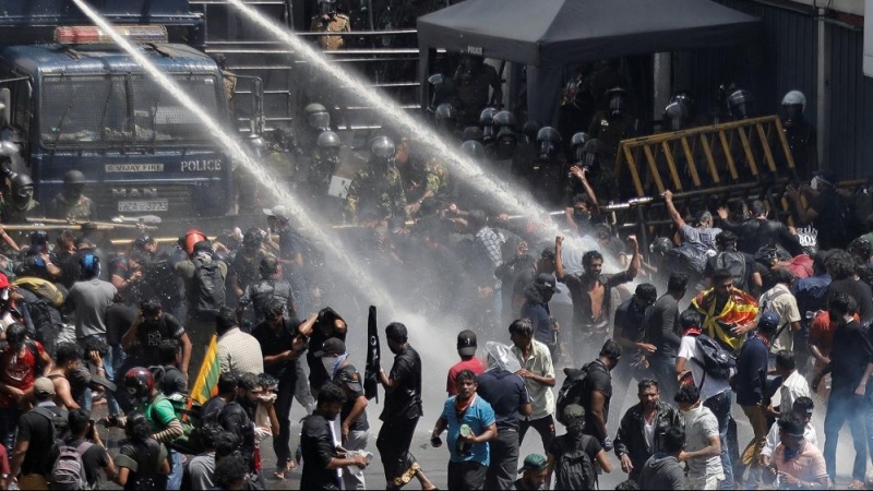 Un grupo de policías disuelve con una manguera de agua a los manifestantes.