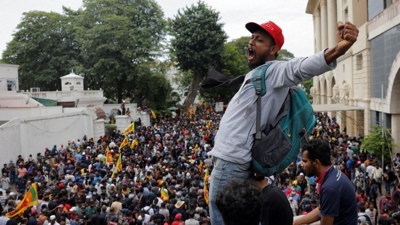 Un hombre jalea a la multitud que le acompaña durante el asalto a la casa presidencial.