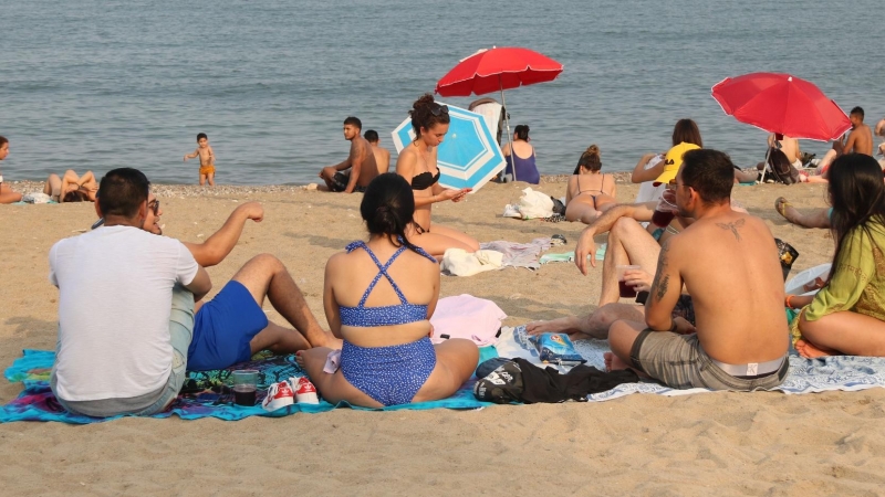 15/08/2021 - Diverses persones a la platja de la Barceloneta en una imatge d'arxiu.