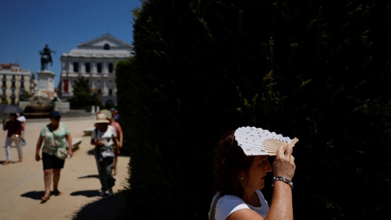 Una se protege del sol con un abanico durante la segunda ola de calor del año en Madrid.