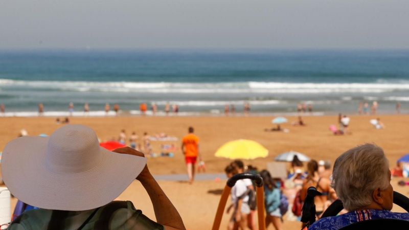 Dos personas discapacitadas esperan a los socorristas para recibir un baño en la playa vizcaína de La Arena, para atenuar la ola de calor que recibe la península.