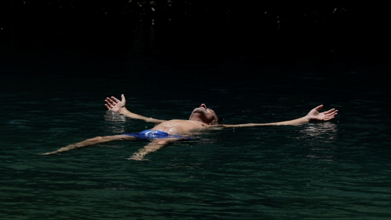 Un turista español se refresca en un lago en el monumento natural Cueva del Gato durante la segunda ola de calor del año, en Benaoján, España, el 14 de julio de 2022. REUTERS/Jon Nazca