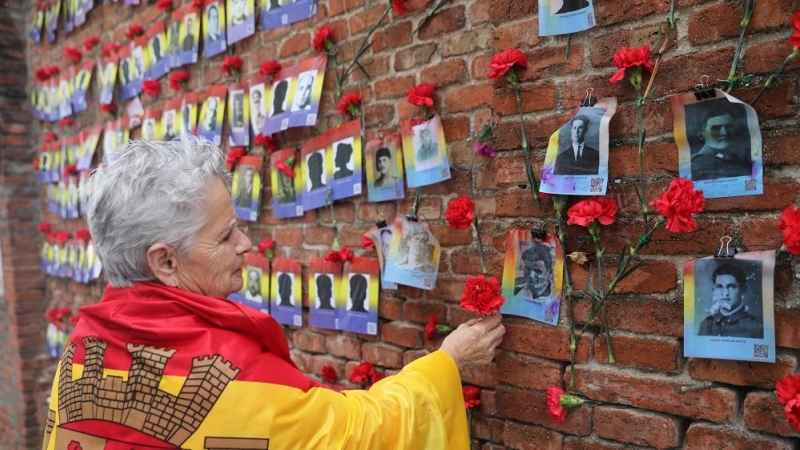 14/07/2022. Una mujer coloca una rosa en una pared durante una ofrenda floral y encuentro abierto entre familiares de las víctimas y estudiantes daneses del franquismo, en el cementerio de La Almudena, a 12 de abril de 2022, en Madrid