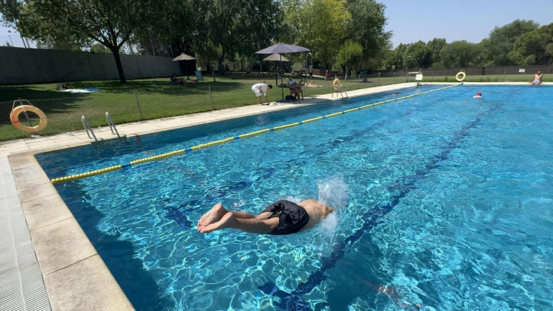 Un hombre se tira de cabeza a la piscina municipal del municipio madrileño de Villaviciosa de Odón para combatir las altas temperaturas de este viernes producidas por la ola de calor que golpea a España.
