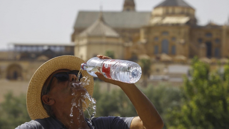 Un turista bebe agua ante la Mezquita-Catedral de Córdoba para combatir la ola de calor este sábado.