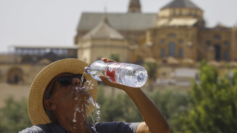 Un turista bebe agua ante la Mezquita-Catedral de Córdoba para combatir la ola de calor este sábado.