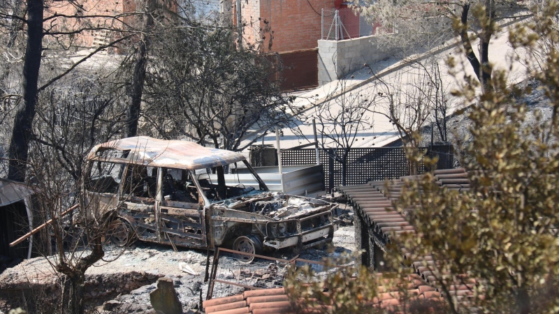 Un vehicle cremat al costat d'una casa a la urbanització de River Park, al Pont de Vilomara.