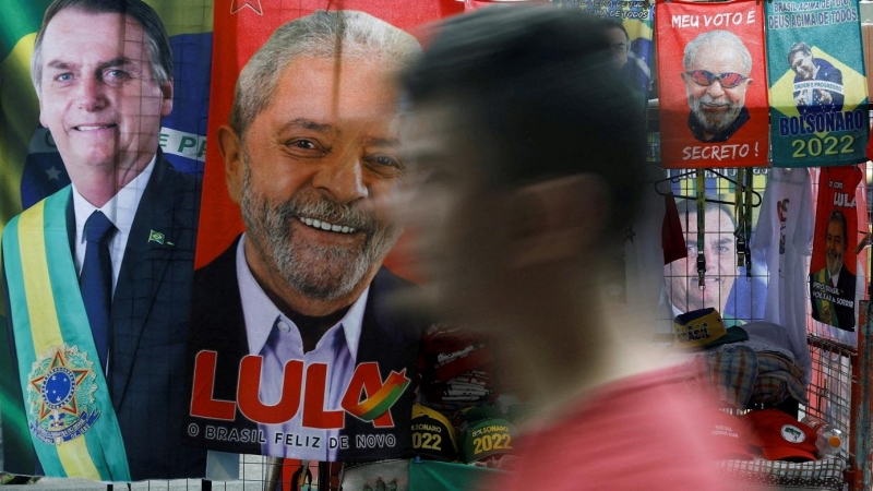 20/07/2022-Un hombre pasa junto a toallas expuestas y materiales de campaña presidencial que representan al ex presidente de Brasil Luiz Inacio Lula da Silva y al presidente de Brasil Jair Bolsonaro, en Río de Janeiro, Brasil, 20 de julio de 2022.