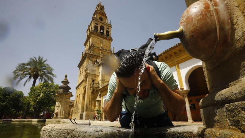 Un turista se refresca en una de las fuentes del patio de los naranjos de la Mezquita - Catedral en una jornada con altas temperaturas y avisos naranja