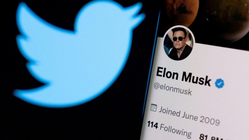 La cuenta de Twitter de Elon Musk en un teléfono frente al logotipo de Twitter