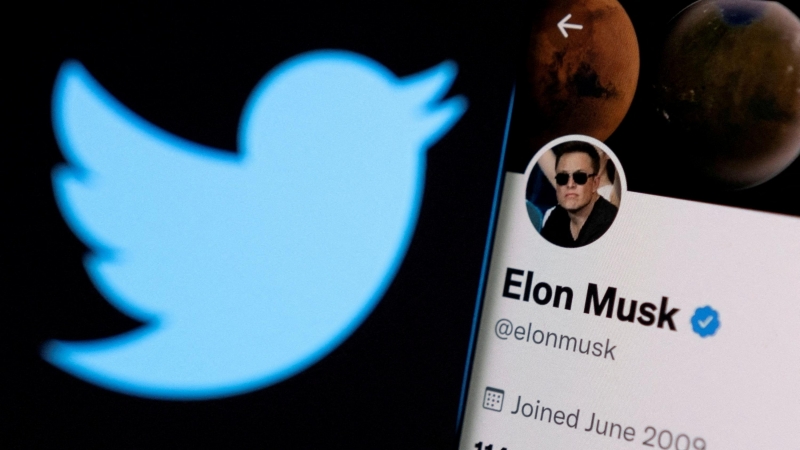 La cuenta de Twitter de Elon Musk en un teléfono frente al logotipo de Twitter