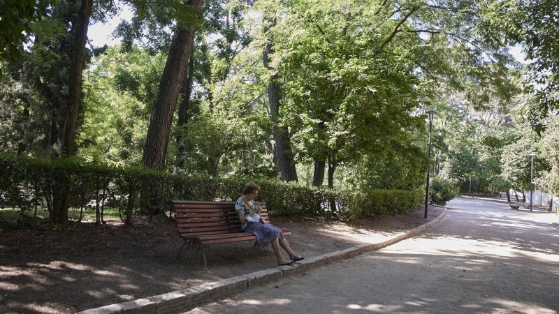 Una señora sentada en un baco del parque Quinta de los Molinos, a 24 de julio de 2022, en el distrito de San Blas-Canillejas, Madrid (España)
