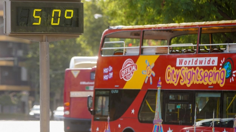 01/08/2022 Un autobús turístico pasa sin pasajeros delante de un termómetro que marca 5Oº en otro día con altas temperaturas en la capital andaluza a 25 de julio del 2022 en Sevilla