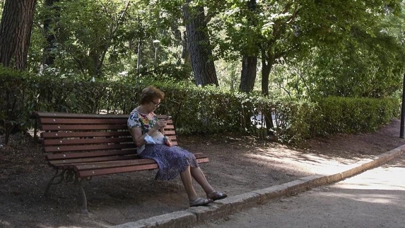 Una señora sentada en un banco del parque Quinta de los Molinos, a 24 de julio de 2022