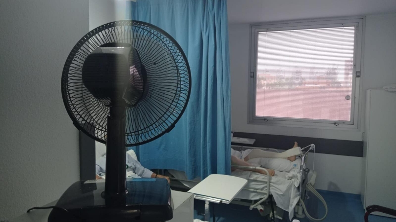 Un ventilador da aire a dos pacientes del Hospital Universitario de Móstoles por la falta de climatización del centro durante el mes de junio de 2022.