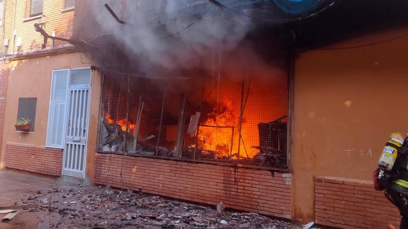 Les flames en l'incendi d'un local a Sant Adrià de Besòs que ha deixat 13 persones ferides per inhalació de fum.