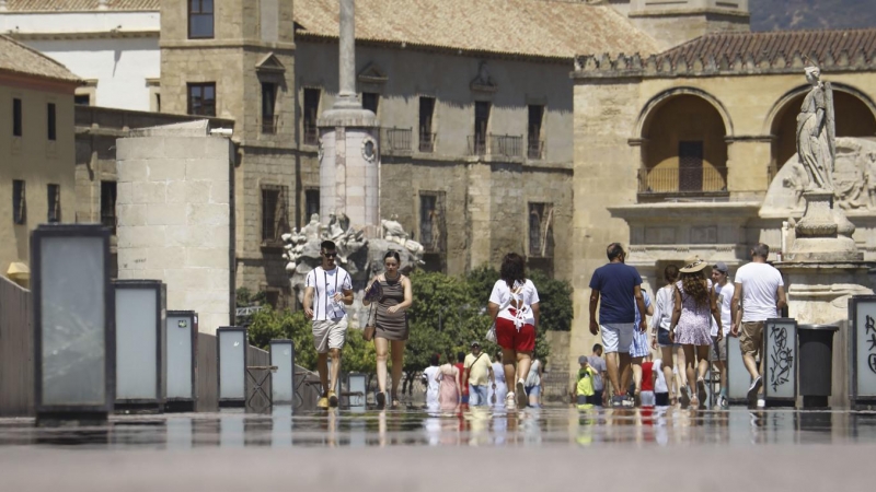 Turistas pasean el pasado 6 de agosto por el puente romano de Córdoba con botellas de agua y abanicos por las altas temperaturas registradas en Córdoba con aviso amarillo por calor.