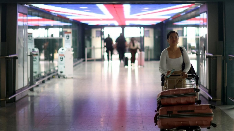 Una pasajera traslada su equipaje en un carrito en la Terminal 5 del aeropuerto londinense de Heathrow . REUTERS/Hannah McKay
