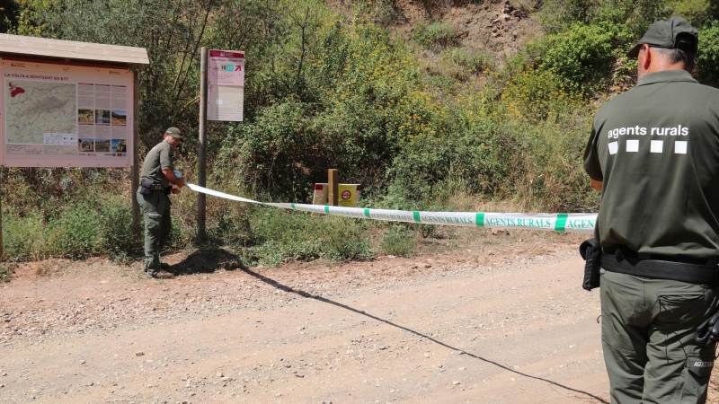 Dos Agents Rurals col·loquen una cinta per impedir l'accés al Parc Natural de la Serra de Montsant des de la Cartoixa d'Escaladei.