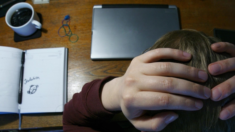 Fotografía de un joven sufriendo estrés en un ambiente de trabajo.