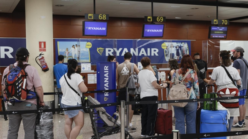 15/08/2022.- Varios pasajeros hacen cola ante uno de los mostradores de facturación en la Terminal 2 del Aeropuerto de Barcelona-El Prat este lunes.