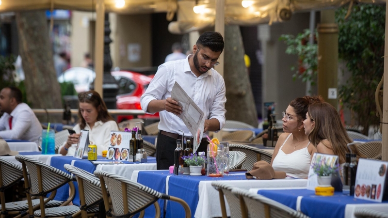 Un camarero atiende a una mesa en las Ramblas, a 15 de junio de 2022, en Barcelona.