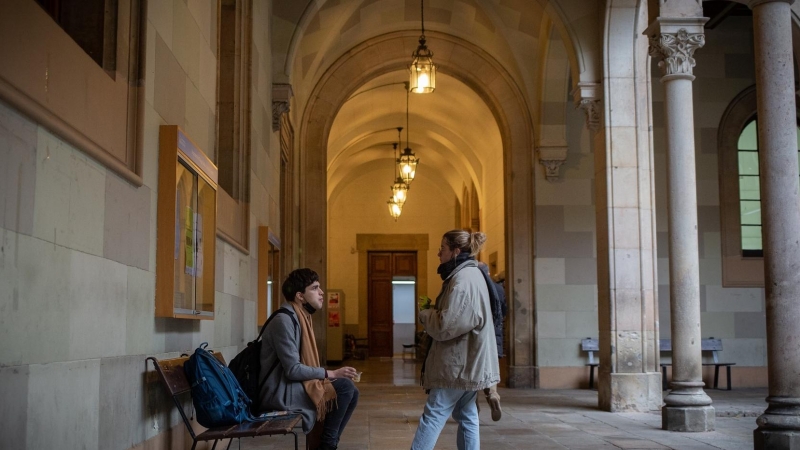 Dos personas en la Facultad de Filología y Comunicación de la Universitat de Barcelona, el edificio central. Imagen de Archivo.