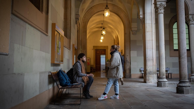 Dos personas en la Facultad de Filología y Comunicación de la Universitat de Barcelona, el edificio central. Imagen de Archivo.