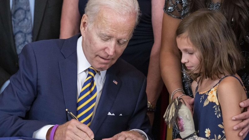 16/8/22 Biden firma una ley en la Casa Blanca, el pasado día 10 de agosto, en presencia de una niña.