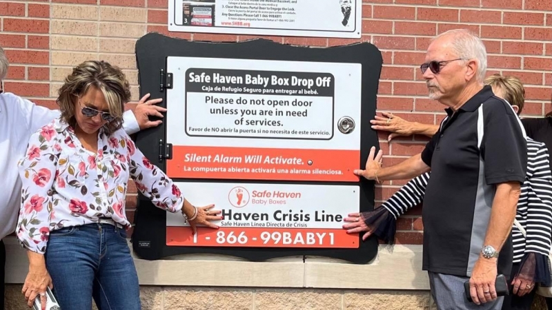 La fundadora de la ONG Safe Haven Baby Boxes, Mónica Kelsey, posa frente a un buzón para bebés.