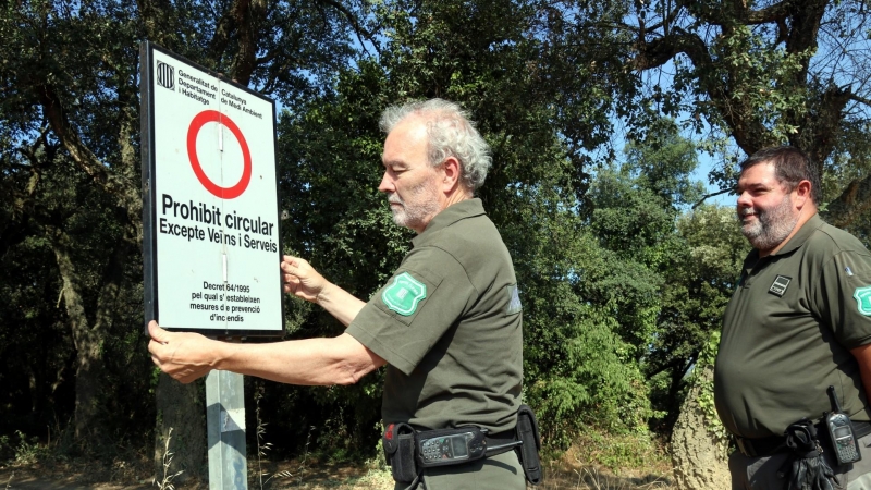 15/08/2022 - Agents rurals col·loquen un cartell sobre les restriccions d'accés a les Gavarres arran de l'activació del pla Alfa.