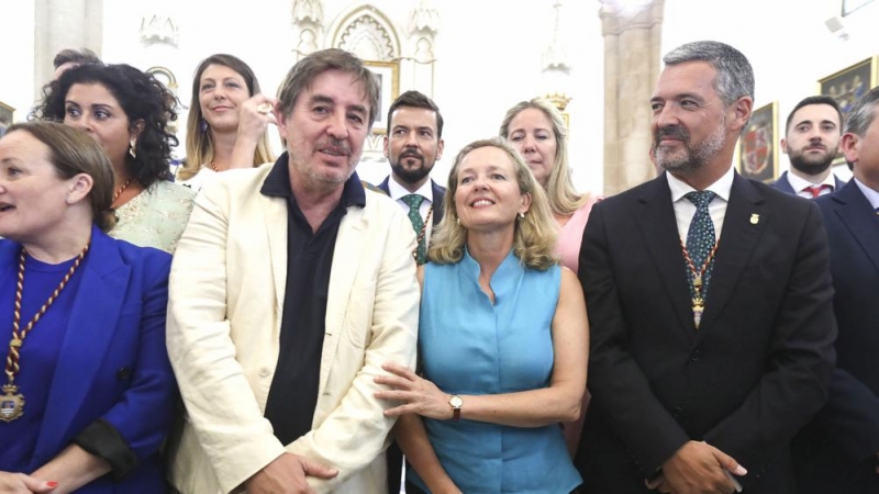 La vicepresidenta primera y ministra de Asuntos Económicos y Transformación Digital, Nadia Calviño, junto al marido de la escritora, Luis García Montero (i) y el alcalde de Rota, José Javier Ruiz Arana (d) durante el acto de nombramiento de Almudena Grand