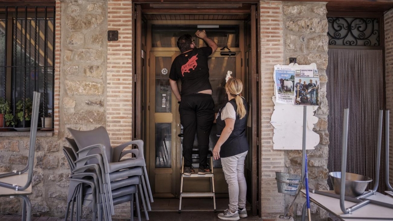 20/08/2022-os personas limpian un bar del pueblo de Bejís (Castellón), a su regreso al pueblo