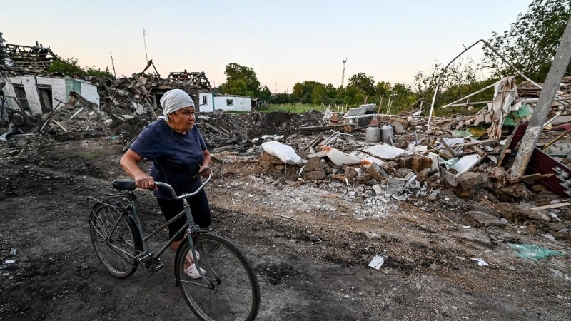 25/08/2022. Una mujer recorre con su bicicleta la zona del siniestro, provocado por un ataque ruso en Chaplyne (Dnipropetrovsk ), a 25 de agosto de 2022.