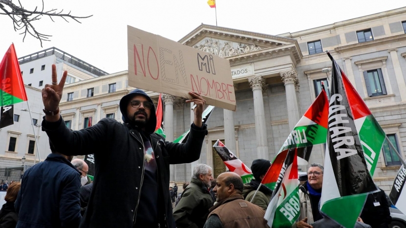 Un manifestante sostiene un cartel en una concentración prosaharaui frente al Congreso de los Diputados, a 30 de marzo de 2022, en Madrid.