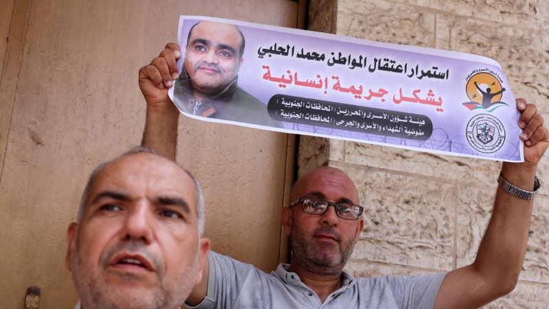 Un hombre sostiene una foto de Mohammad al Halabi, durante una protesta en solidaridad tras la decisión de un tribunal israelí de sentenciarlo a 12 años, en la ciudad de Gaza, el 30 de agosto de 2022.