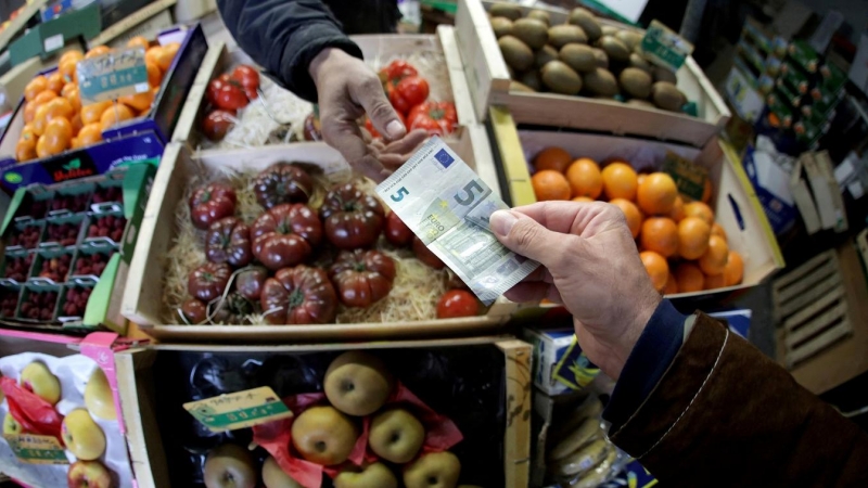 Un cliente paga con un billete de 5 euros en un puesto de fruta de un mercado en Niza (Francia). REUTERS/Eric Gaillard