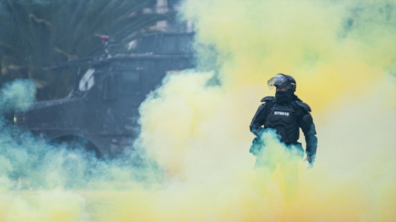 28/04/2022-Un agente de la policía antidisturbios se para entre el humo durante una protesta contra el gobierno del presidente Iván Duque el 28 de abril de 2022