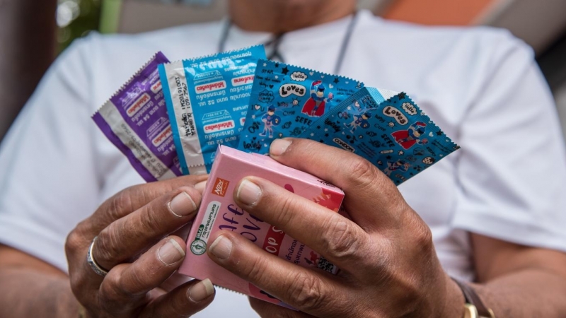 Un hombre sujeta unos condones para el día mundial de concienciación sobre el VIH, a 1 de diciembre de 2021.