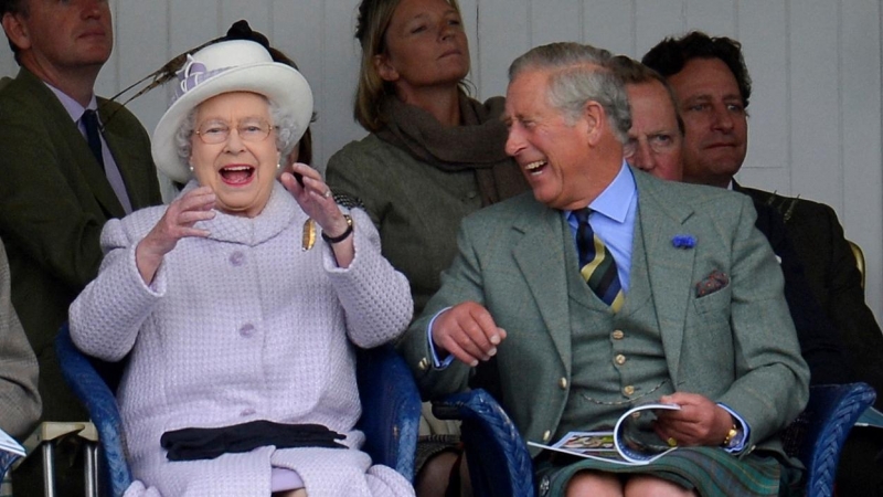 Fotografía de septiembre de2012, de la reina Isabel II y el príncipe Carlos, animando a los participantes en una carrera de sacos en los tradicionales juegos de Braemar Gathering, enEscocia. REUTERS/Russell Cheyne