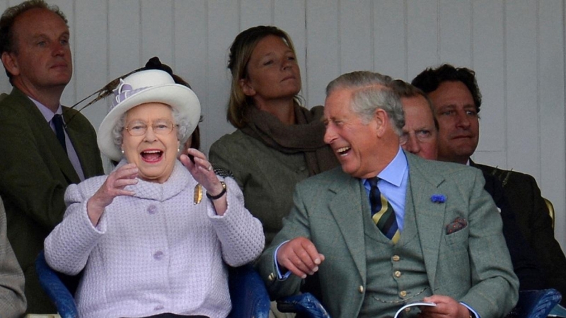 Fotografía de septiembre de2012, de la reina Isabel II y el príncipe Carlos, animando a los participantes en una carrera de sacos en los tradicionales juegos de Braemar Gathering, enEscocia. REUTERS/Russell Cheyne