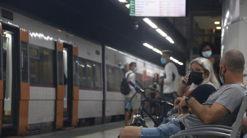 Dos usuaris de Rodalies esperant el seu tren a l'estació de Sants de Barcelona, durant la jornada de vaga dels maquinistes de Renfe d'aquest dijous.