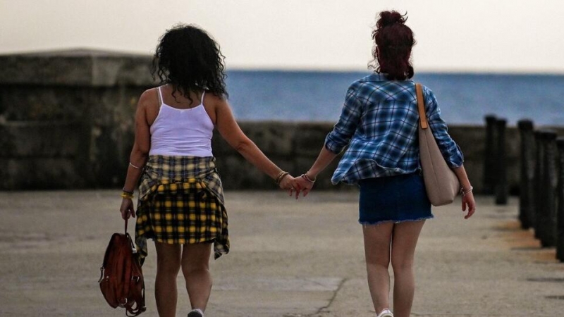 Una pareja andando por Malecón en La Habana