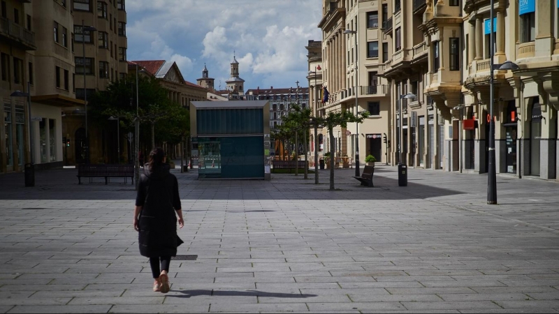 Una mujer camina por la comercial Avenida Carlos III de Pamplona, prácticamente vacía por sus tiendas cerradas durante el estado de alarma decretado por la pandemia de la covid-19. E.P./Eduardo Sanz